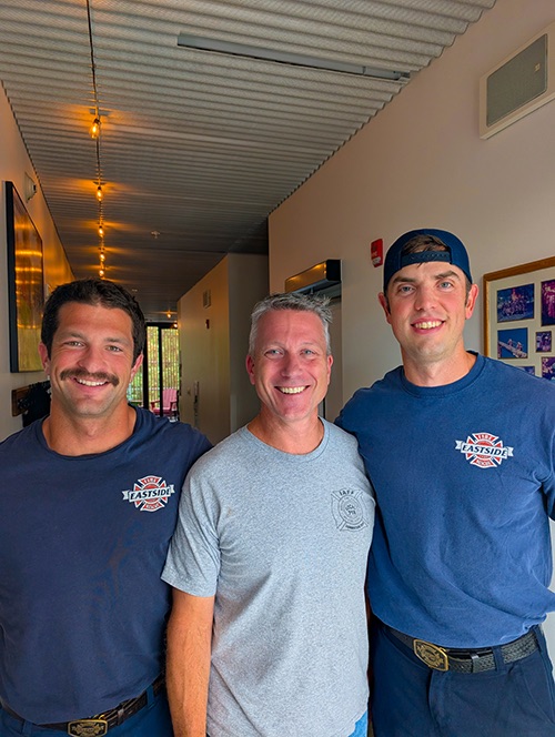 Ray Austin standing with two Eastside firefighters